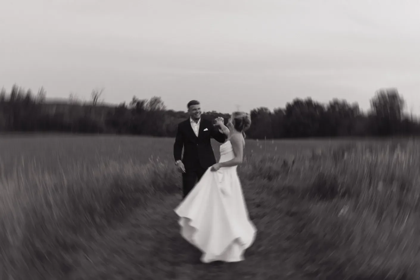 Black and white photograph of a couple together in a field of tall grass